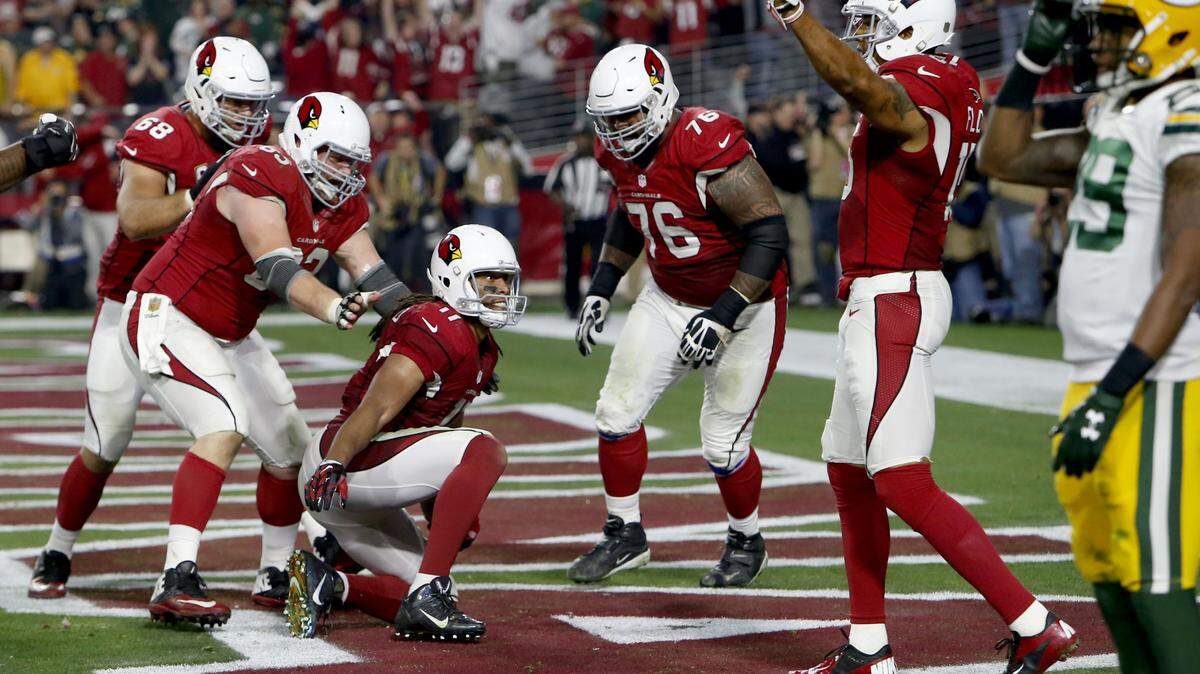 FILE - In this Jan. 16, 2016, file photo, Arizona Cardinals wide receiver Larry Fitzgerald (11) celebrates his game-winning touchdown with teammates against the Green Bay Packers during overtime of an NFL divisional playoff football game in Glendale, Ariz. The Cardinals won 26-20. Green Bay linebacker Clay Matthews summed up the problem with the NFLís current overtime rule quite nicely when not even Aaron Rodgersí latest heroics could save the Packers from yet another playoff loss. ìWhen you are on the losing side, you want to see it changed,íí Matthews said. (AP Photo/Rick Scuteri)