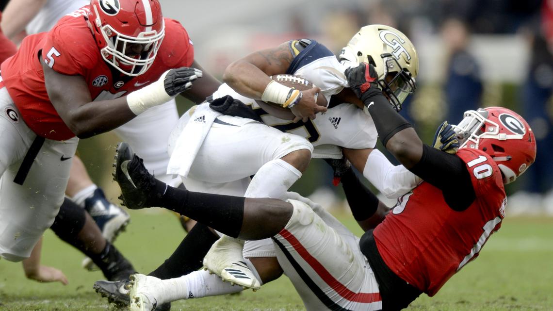 Georgia Tech quarterback TaQuon Marshall (16) is stopped in the backfield by Georgia defensive lineman Malik Herring (10) during the Bulldogs 45-21 win over Georgia Tech.