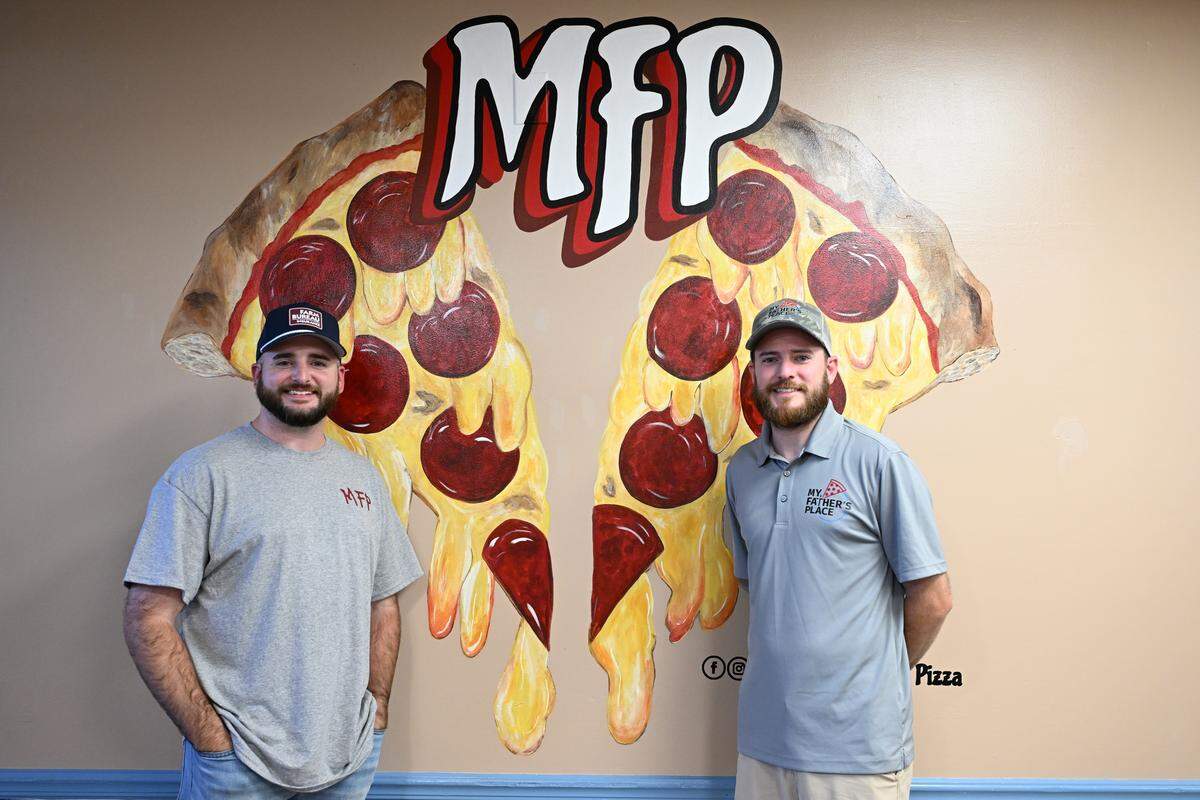 Brothers Jonathan Kline (left) and Jacob Kline, who co-own My Father’s Place 50/50, pose in front of a new mural near the front counter of My Father’s Place on Tuesday, Aug. 19, 2025, in Warner Robins, Georgia. Jacob Kline’s wife, Hope Kline, and her mom, Tracy “Gigi” Wheeler, did all of the artwork in the restaurant.