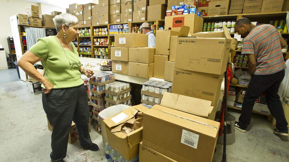 Judy Sexton, director of the Loaves & Fishes Day Services Center in Macon, looks over a freshly stocked pantry. The ministry gives groceries to the needy on Wednesdays.  