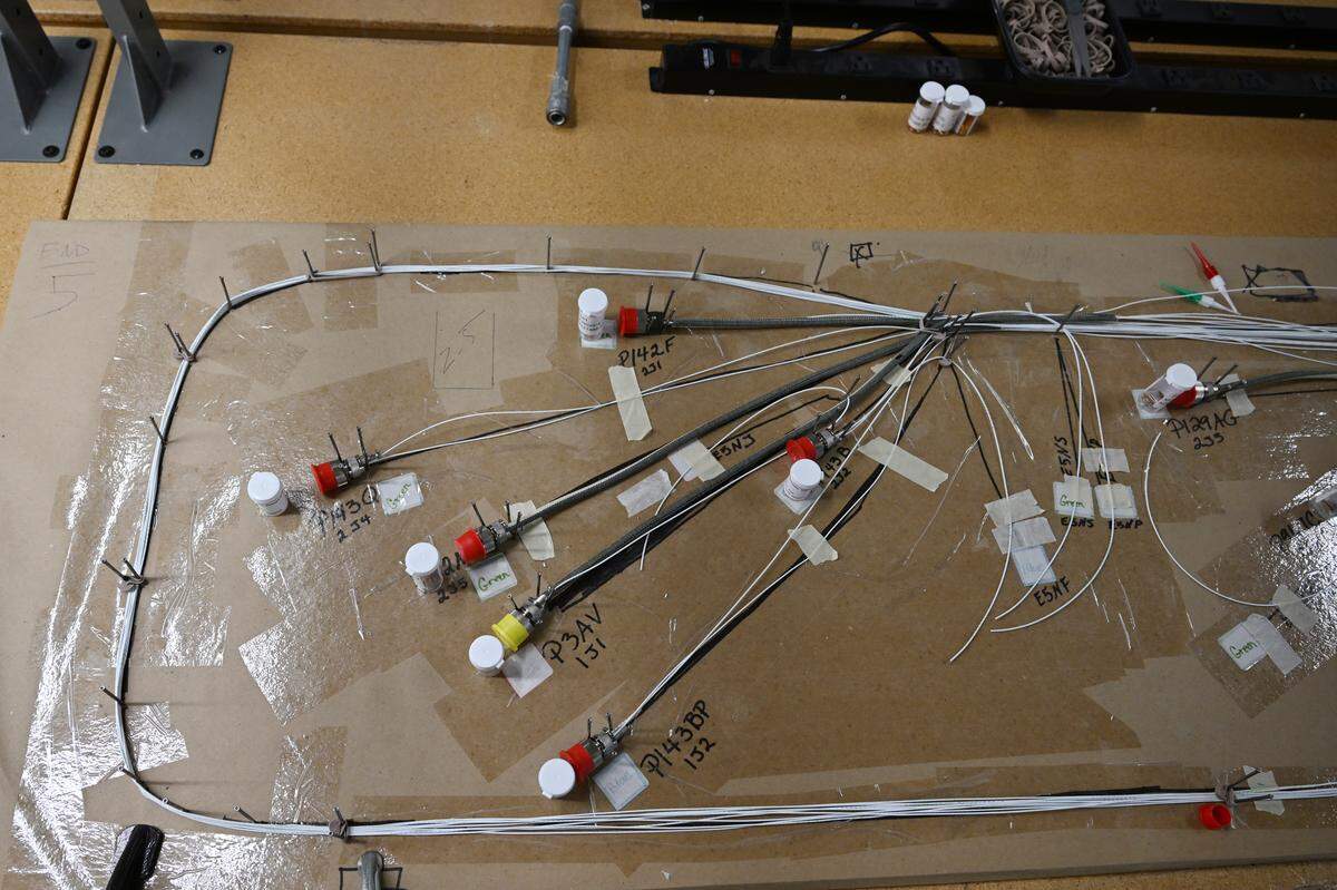 Upgraded wiring is laid out and marked for length on a wiring board across a long table inside a workshop inside the new KIHOMAC aerospace manufacturing and engineering plant in Warner Robins.
