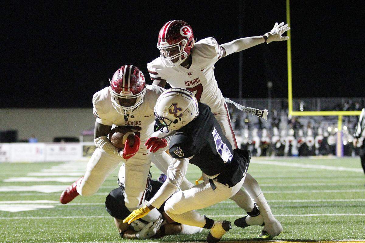 Warner Robins’ Jafredrick Perry (6) forces his way in for a TD late in the second quarter of the Demons playoff game at Jones County.