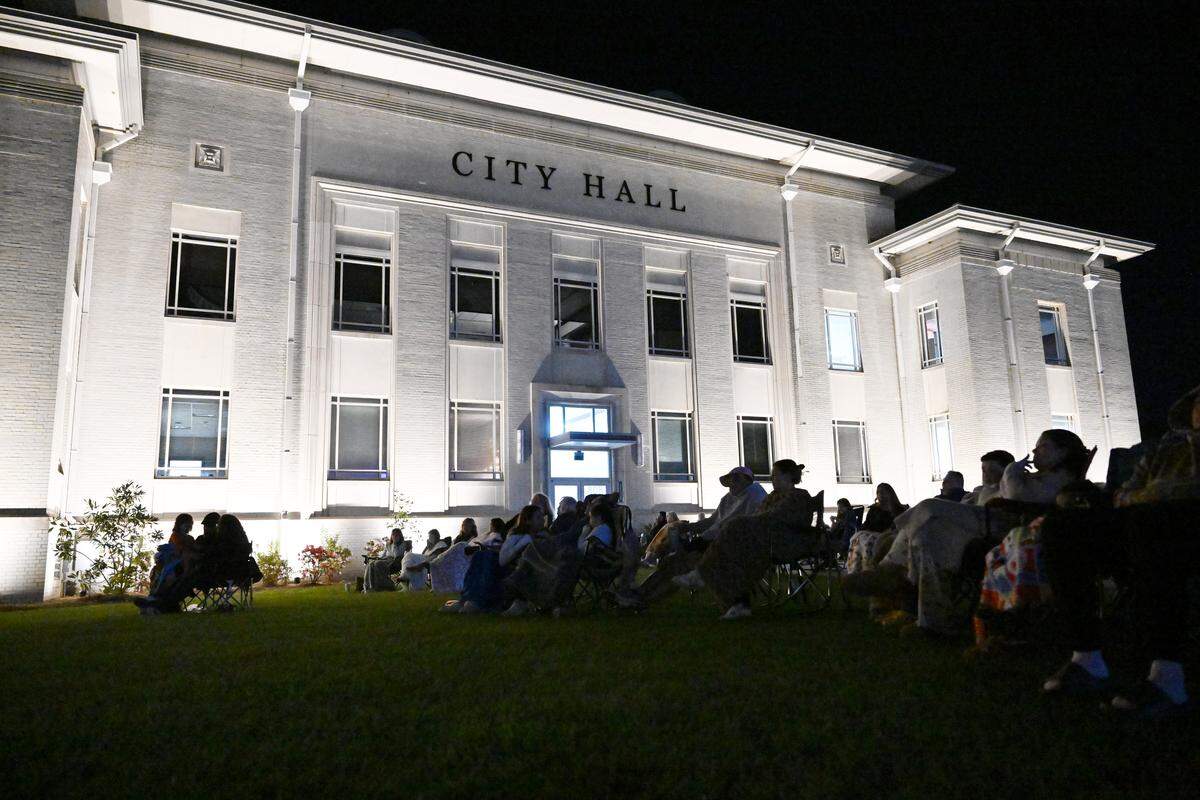 Friends, family and fans gather on the lawn of city hall of downtown Perry to watch Sweet Evelyn’s owner, Cory Jones, compete in the “Halloween Baking Championship” on Monday, Oct. 20, 2025.