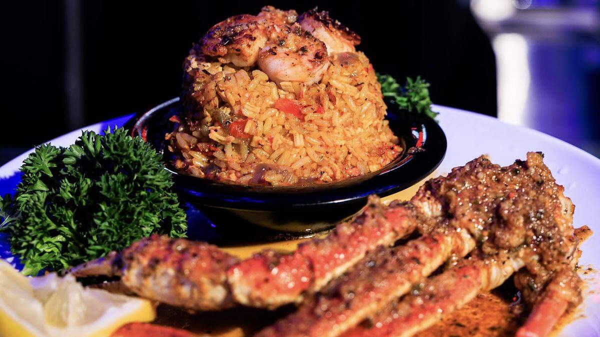 Prominent Restaurant’s royaltee seafood rice. The dish is described on the menu as seasoned sazon rice with a combination of shrimp, crab meat and sausage served with one snow crab cluster. This photo has been cropped.