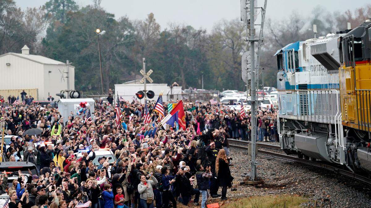 People pay their respects as the train carrying the casket of former President George H.W. Bush passes Thursday along the route from Spring to College Station, Texas.