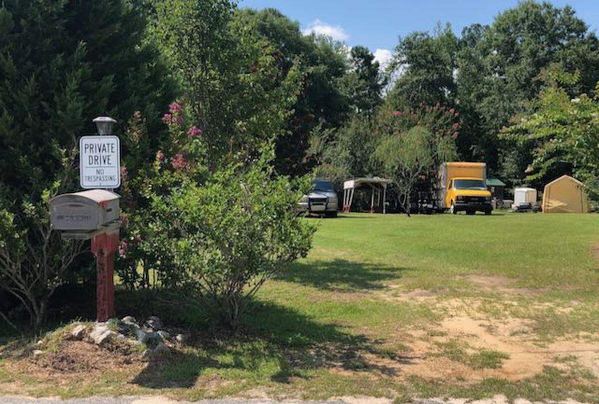 A “no trespassing” sign is posted on Greg Cutlip’s mailbox in Lizella. A judge ruled he must let code enforcement officers onto the property to see if his lawnmowers and vehicles can be cranked and moved.