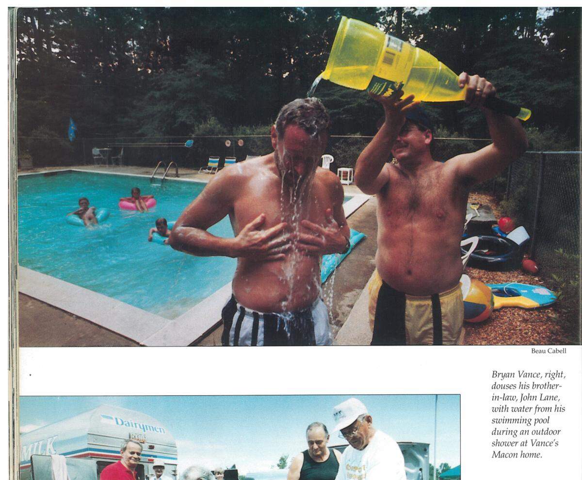 Bryan Vance, right, douses his brother-in-law, John Lane, with water from his swimming pool during an outdoor shower at Vance’s Macon home during the flood of 1994.