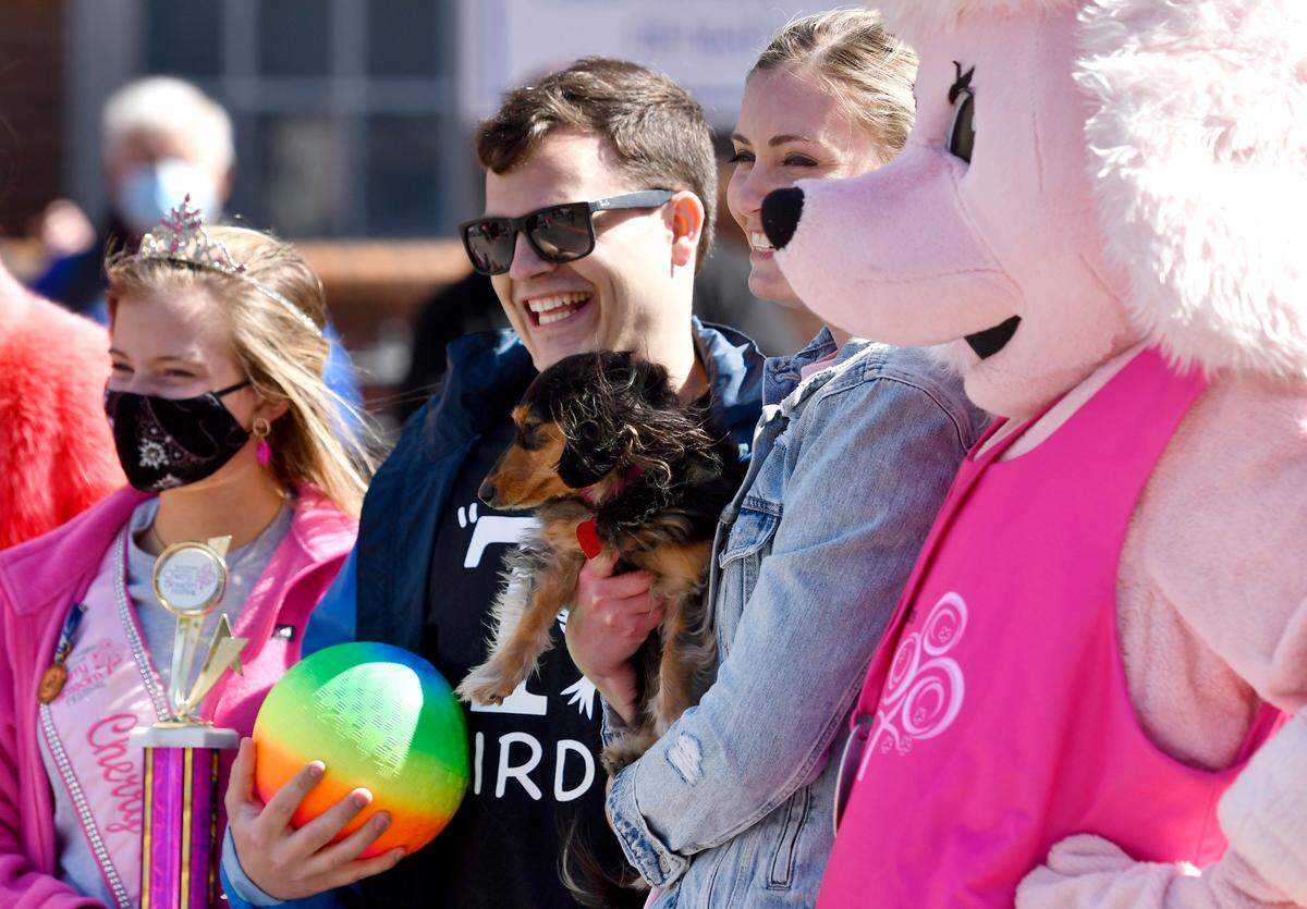 Macy and Clay Akridge pose for a picture with their dachshund Lucy Saturday after winning the Cherry Blossom Festival Wiener Dog Race.