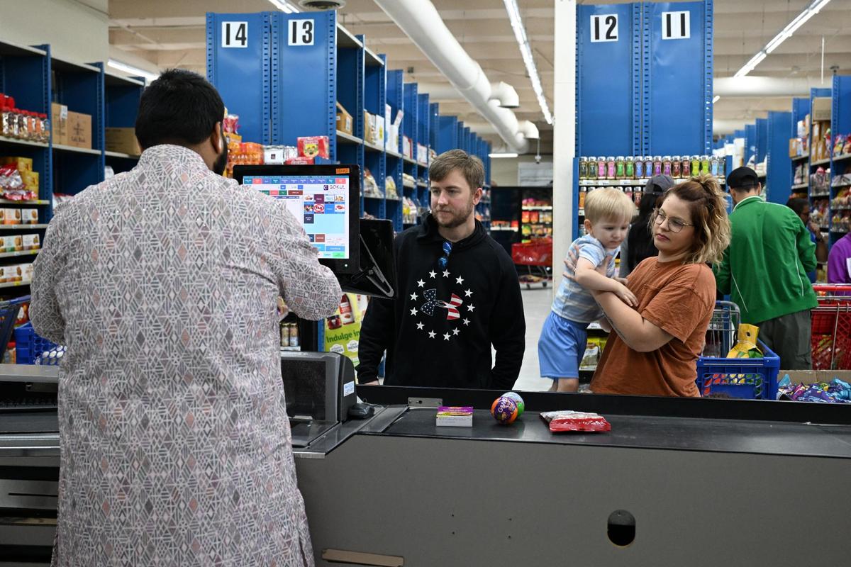 Michael Glass (second from left) and Kaylan Glass, with their son, M.J., and a friend’s child, Scarlett Fritts (not pictured), check out at the Maharaja Market during its grand opening on Wednesday, April 16, 2025, in Warner Robins. Michael Glass works with Malay Patel, whose parents are among the owners.