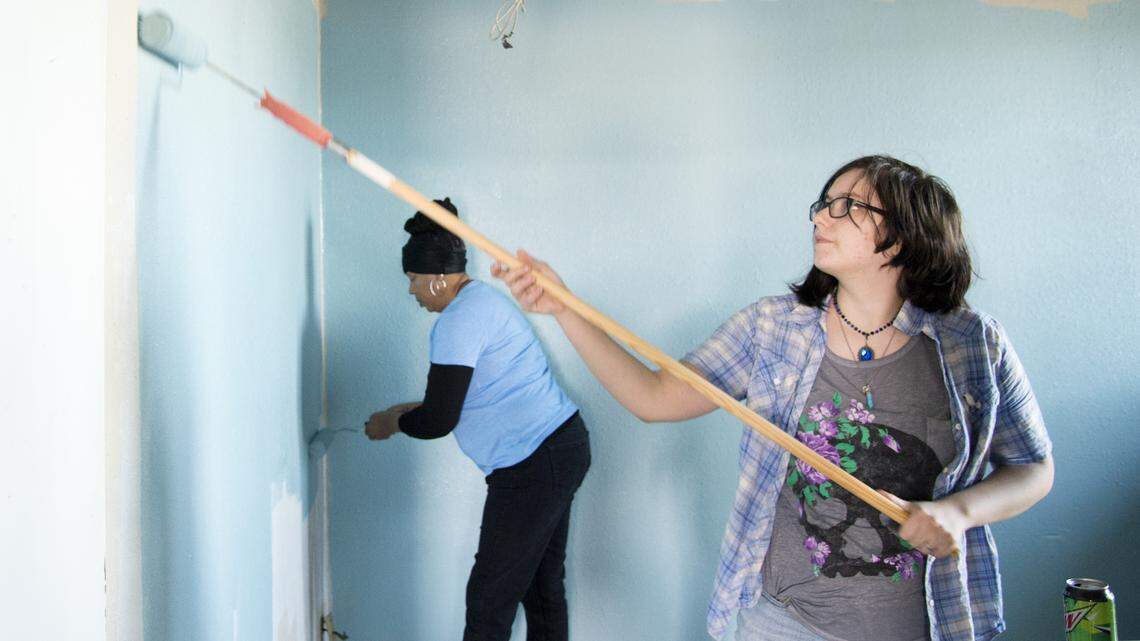 Volunteer Trista Sheffield helps paint the walls in the administrative office at Home Port Veterans Transition Home in Macon during a work day Saturday.