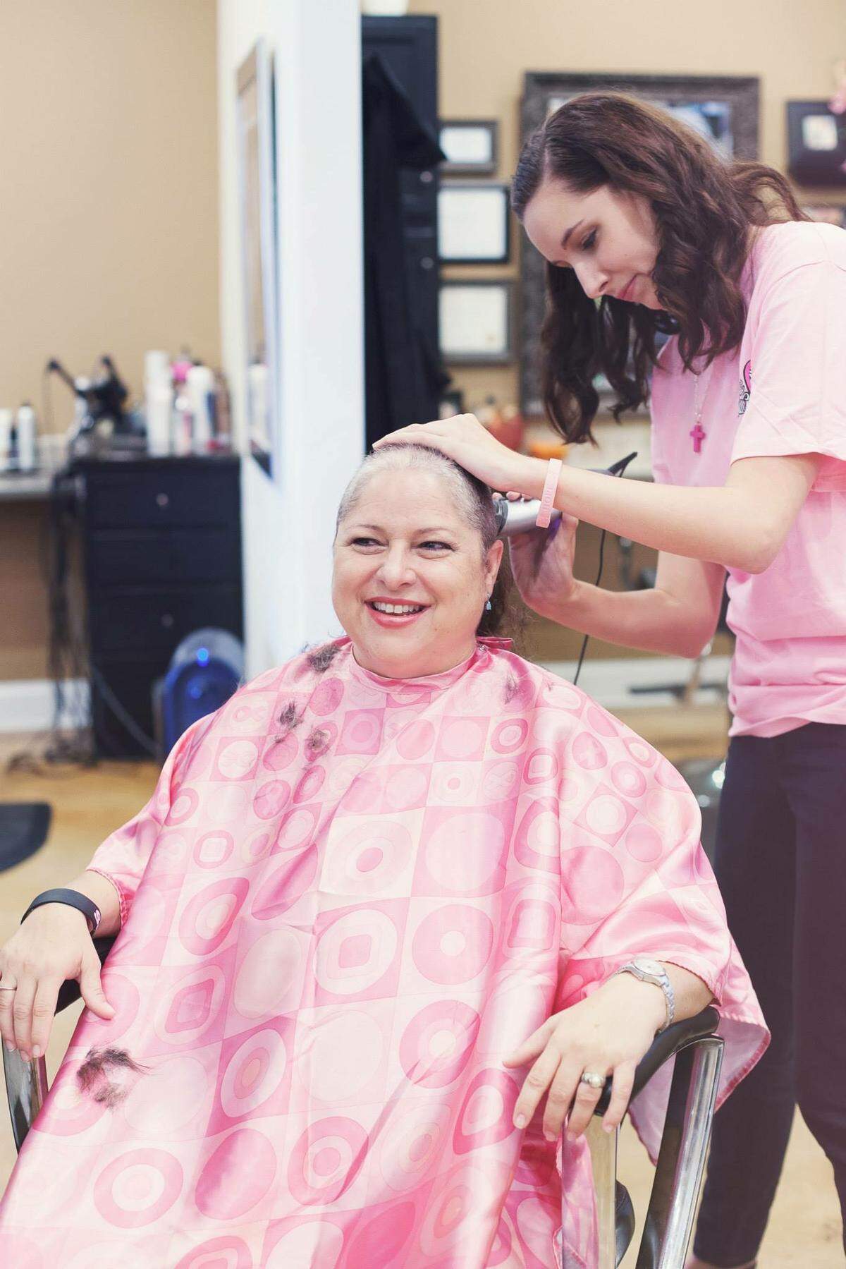 Sabrina Griffin’s daughter, Savannah Calhoun, shaves her mother’s hair at a head-shaving party.