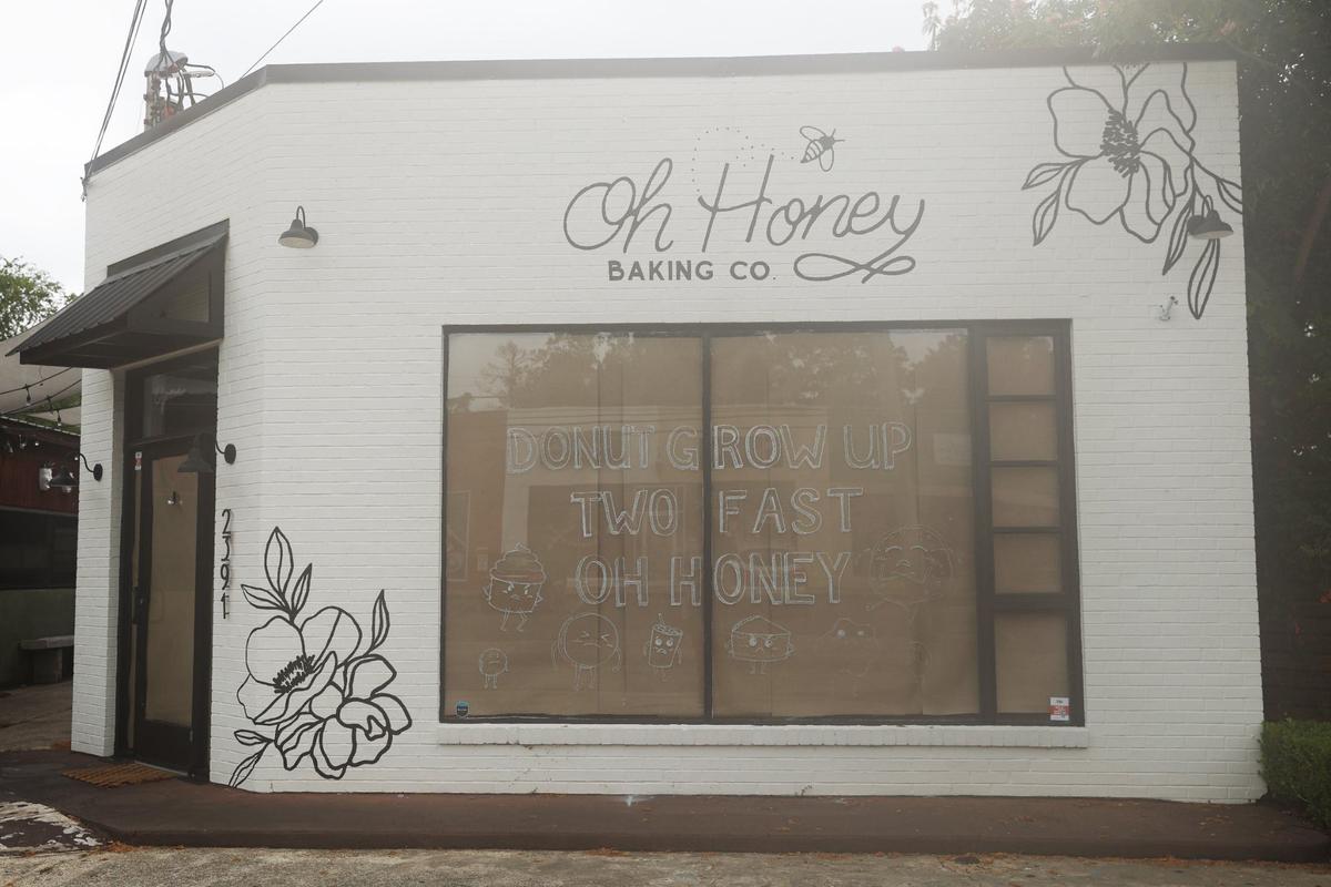 Oh Honey sits with cardboard in the windows after closing with “Donut Grow Up Two Fast Oh Honey” written in the window off of Ingleside Avenue on Wednesday, July 3, 2024, in Macon, Georgia. Oh Honey announced on Monday that it would close effective immediately.