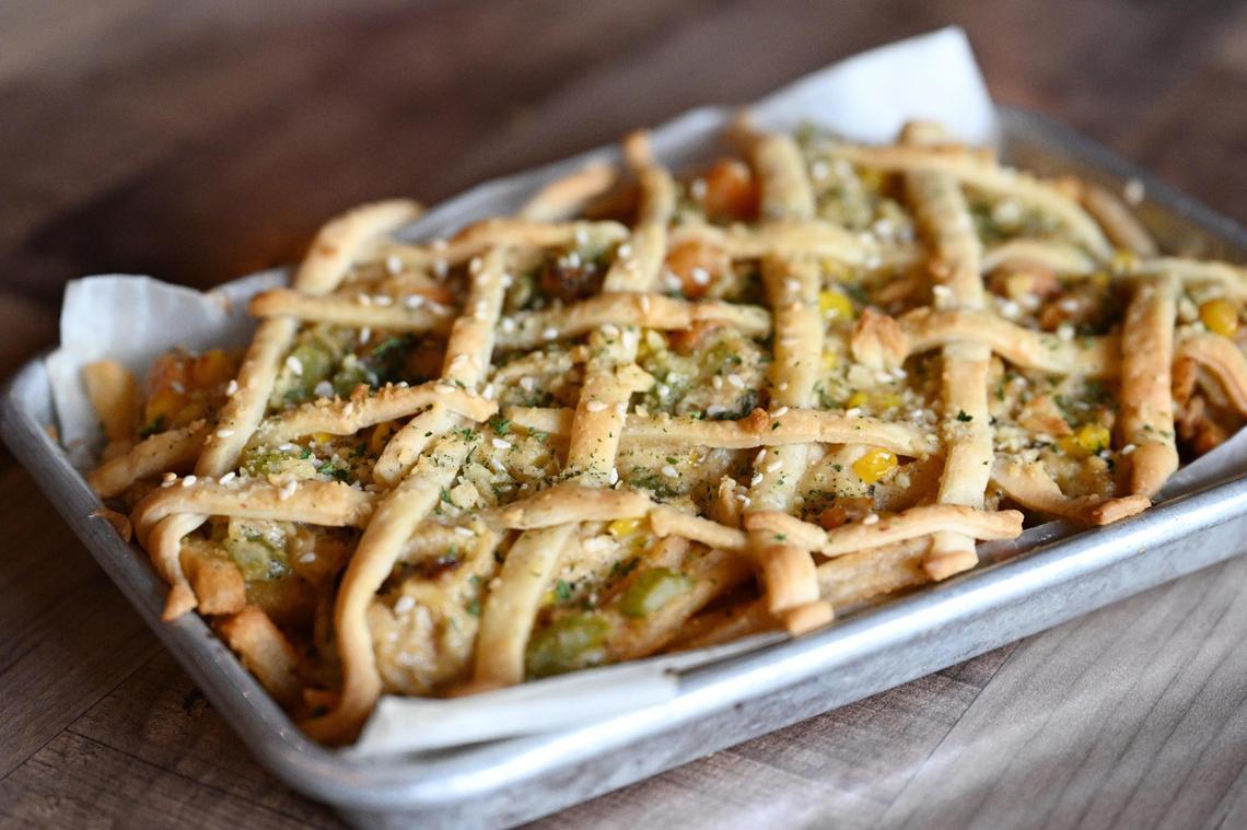 The Chicken Pot Fry, Cashman Pub’s 2025 Downtown Macon French Fry Fight submission, sits inside of Cashman’s Pub on Thursday, July 3, 2025, in Macon, Georgia. The dish features a base of shoestring fries layered with chicken, vegetables and white sauce, with a lattice pastry design on top.