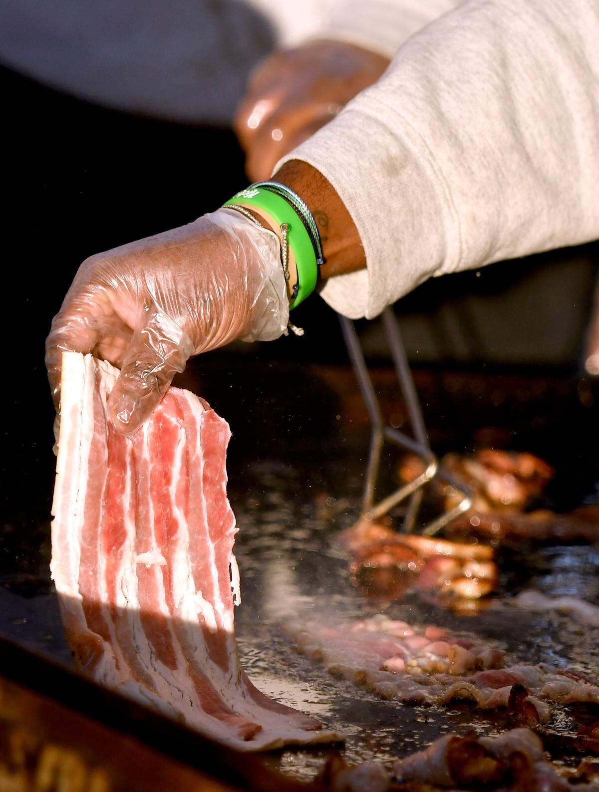 Members of the Macon-Bibb County Fire Department grill bacon Saturday morning during the Cherry Blossom Festival Pink Pancake Breakfast at Luther Williams Field.