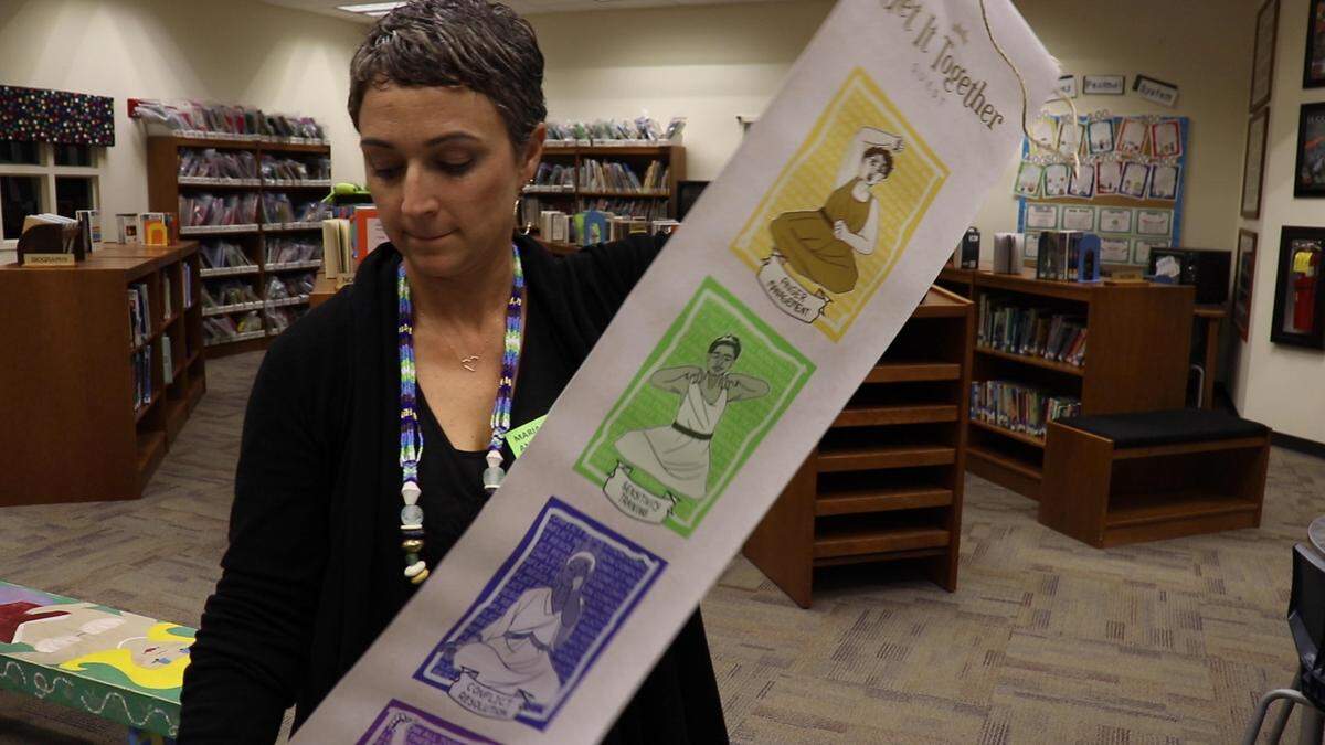 Maria Andrade, executive director of On the Same Breath, rolls up a banner she uses to demonstrate breathing exercises to elementary school students. The program is focused on creating mindfulness and improving self esteem in kids as a way to potentially manage behavioral issues at school.