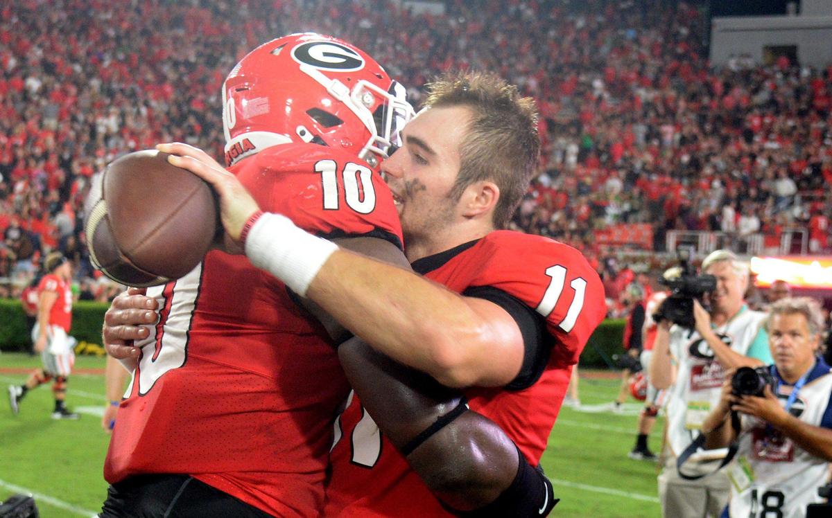 Georgia quarterback Jake Fromm (11) hugs teammate Malik Herring (10) after the Bulldogs’ 23-17 win over Notre Dame Saturday night in Athens.