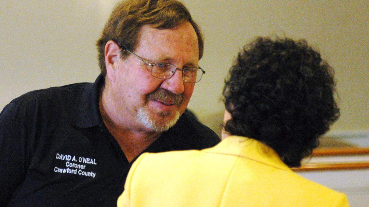 Crawford County Coroner David Allen O'Neal talks to his attorney, B. Michelle Smith of Warner Robins, after a hearing into O'Neal's lawsuit against county commissioners concluded April 22.