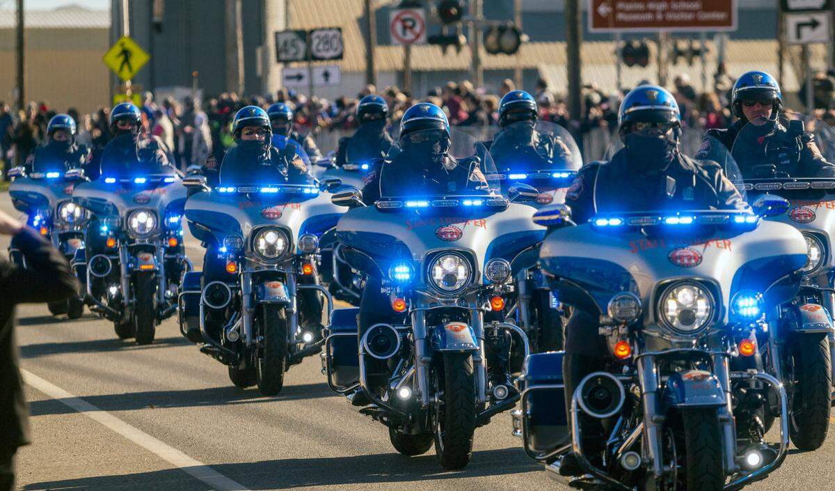 Law enforcement motorcycle escorts trail behind a hearse carrying Jimmy Carter and the remainder of the procession in downtown Plains, Ga. on Saturday, Dec. 4, 2025.