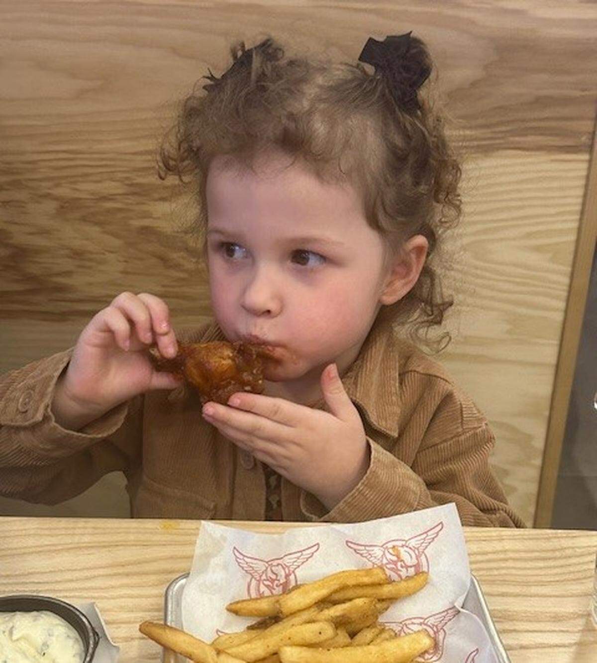 Toddler tries Taco Mac’s wings, “It’s so good,” she said.
