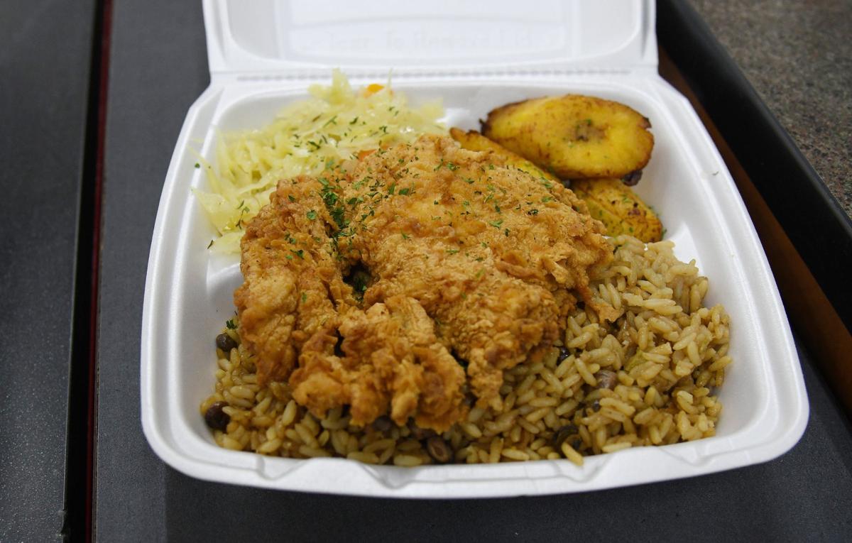 Cracked chicken with peas and rice, plantains and steamed cabbage rests on a countertop on Thursday, Aug. 15, 2024, at Bahamas Caribbean Cuisine in Warner Robins, Georgia. The new restaurant that serves authentic Bahamian food.