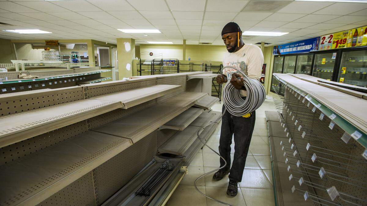 Stephen Cotton unrolls flexible conduit for electrical wiring in the old Bateman & Wade grocery building on Clayton Street.