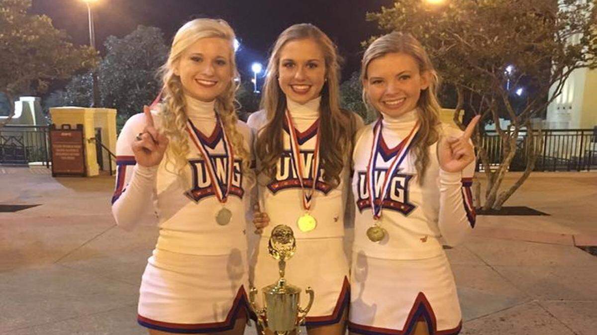From left, Cori Samples, Jamie Preston and Taylor Jordan, members of the University of West Georgia cheer team, pose with the national championship trophy the team won in Orlando, Florida. Preston cheered at Houston County High.