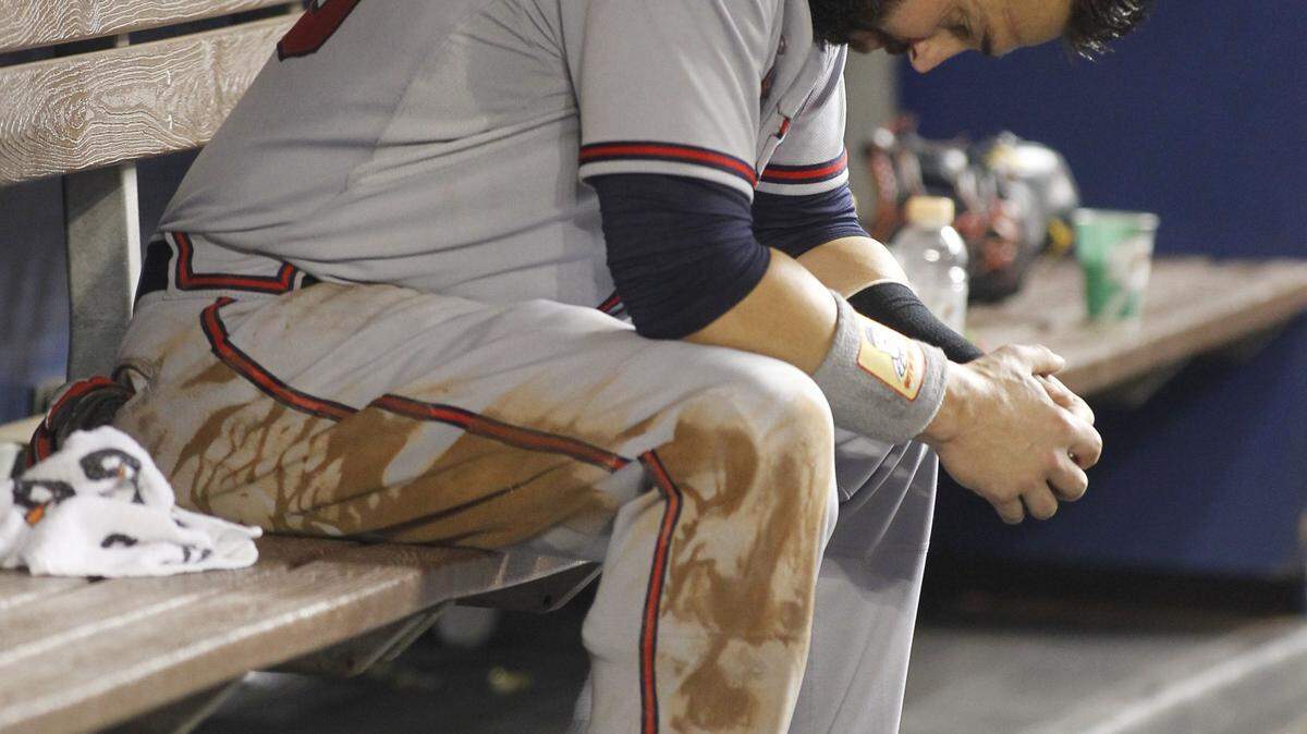 Atlanta Braves left fielder Nick Swisher (23) reacts in the dugout after he was tagged out at second base in the fourth inning of play against the Miami Marlins during a baseball game in Miami, Saturday, Sept. 26, 2015. (AP Photo/Joe Skipper)
