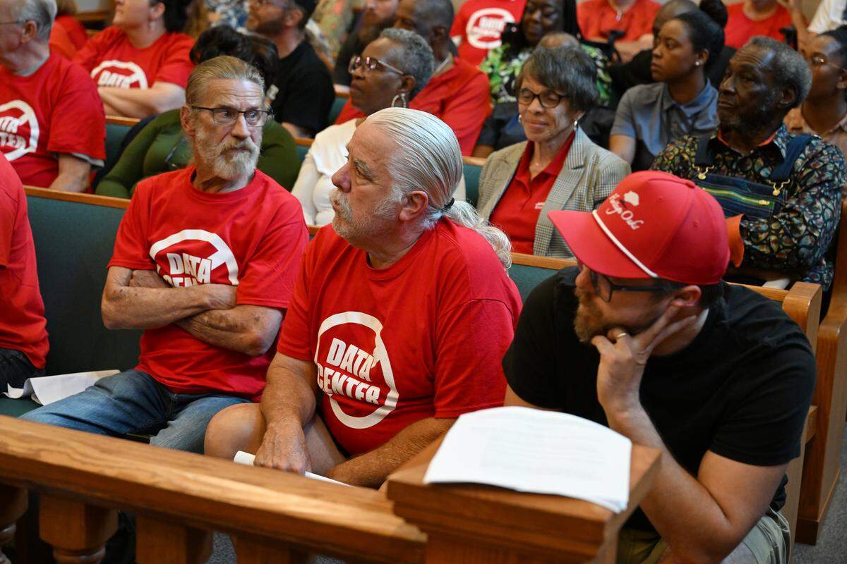 Meeting attendees sit in a packed courthouse, some in shirts expressing opposition to data centers, on Thursday, Sept. 18, 2025, at the Twiggs County Courthouse in Jeffersonville, Ga. The Twiggs County Board of Commissioners voted unanimously to approve rezoning of agricultural land to land for a proposed data center with some conditions.