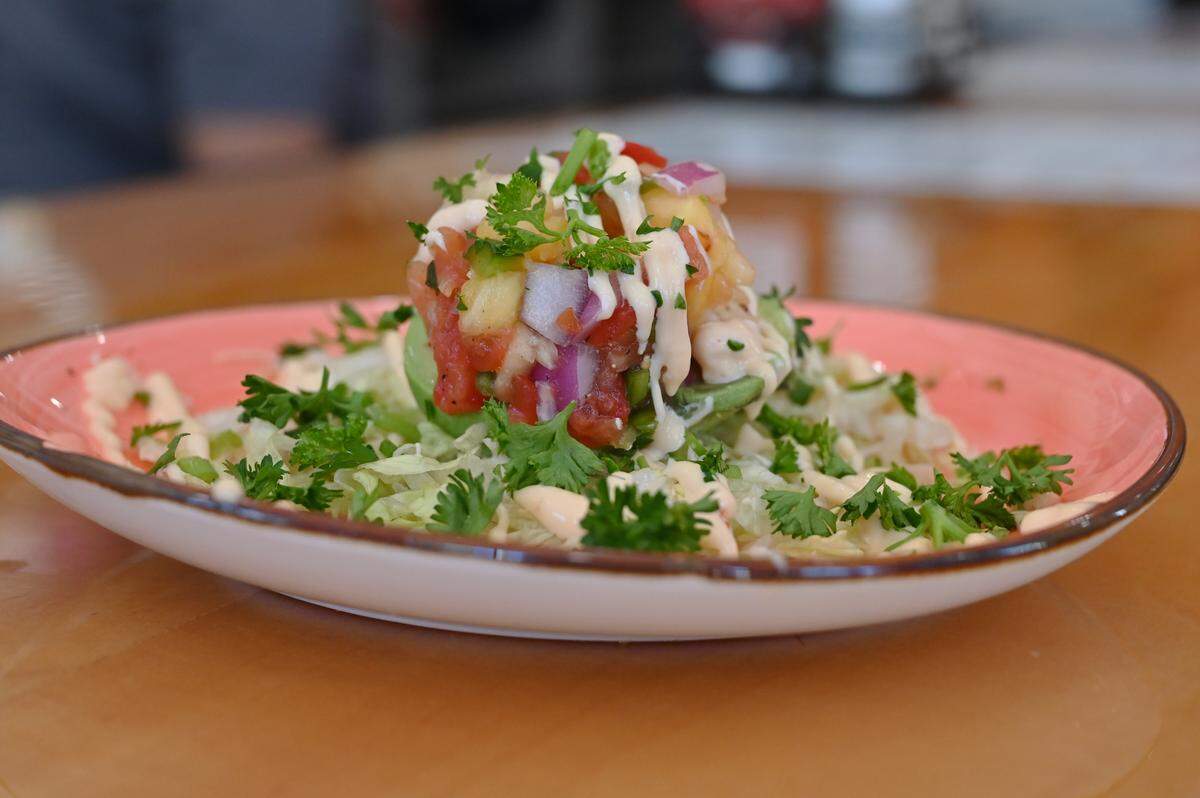 The Avocado Boat appetizer sits on the counter at Flying Biscuit Cafe on Saturday, July 26, 2025, in downtown Macon, Georgia. The dish features a half avocado topped with pineapple pico, spicy Thai chili sauce and shredded lettuce. 