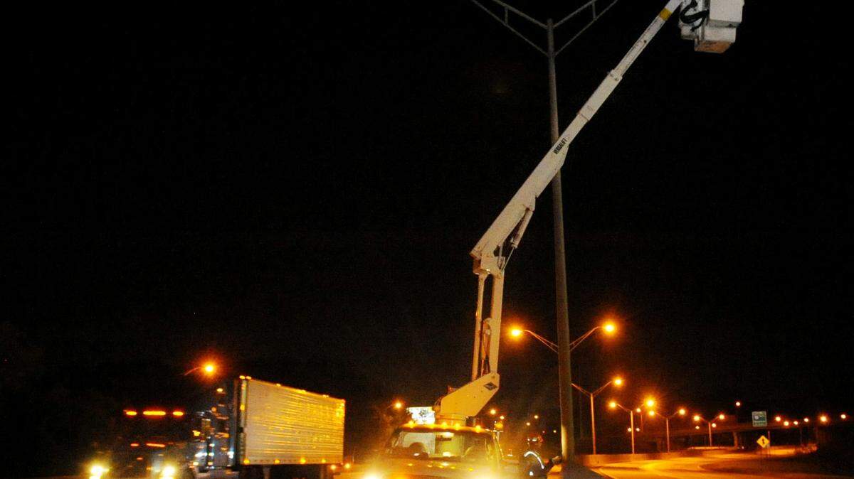 City electrician Randy McCarty finishes up work on a street light on Interstate 75 near Mercer University as traffic goes by.