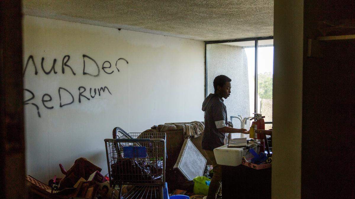 Darrell Osgood walks through a squat down the hall from his apartment in Macon, Ga. Despite utilities rolled into rent, management recently let the water get cut off. It’s only the latest indignity that has residents wanting to talk to corporate, but the people behind corporate, Crystal Lakes Holdings LLC, are protected by the law.