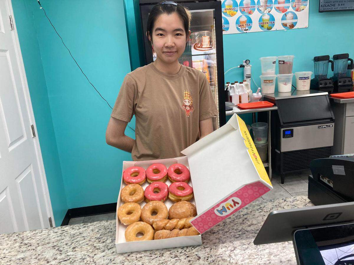 Kimhang Eang displays a box of freshly made doughnuts at Ray’s Donuts in Warner Robins. The doughnuts are 99 cents each except the $3 maple bacon flavor.