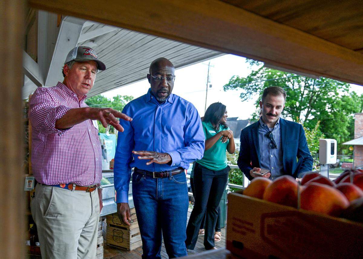 State Rep. Robert Dickey, left, talks with U.S. Senator Raphael Warnock Tuesday while giving Warnock a tour of the Dickey Farms packinghouse. Warnock hosted a roundtable with Georgia farmers to discuss stress and mental health.