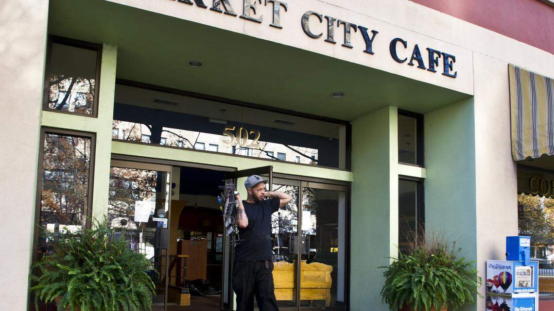 A Market City Cafe employee moves signs from the restaurant Friday afternoon.