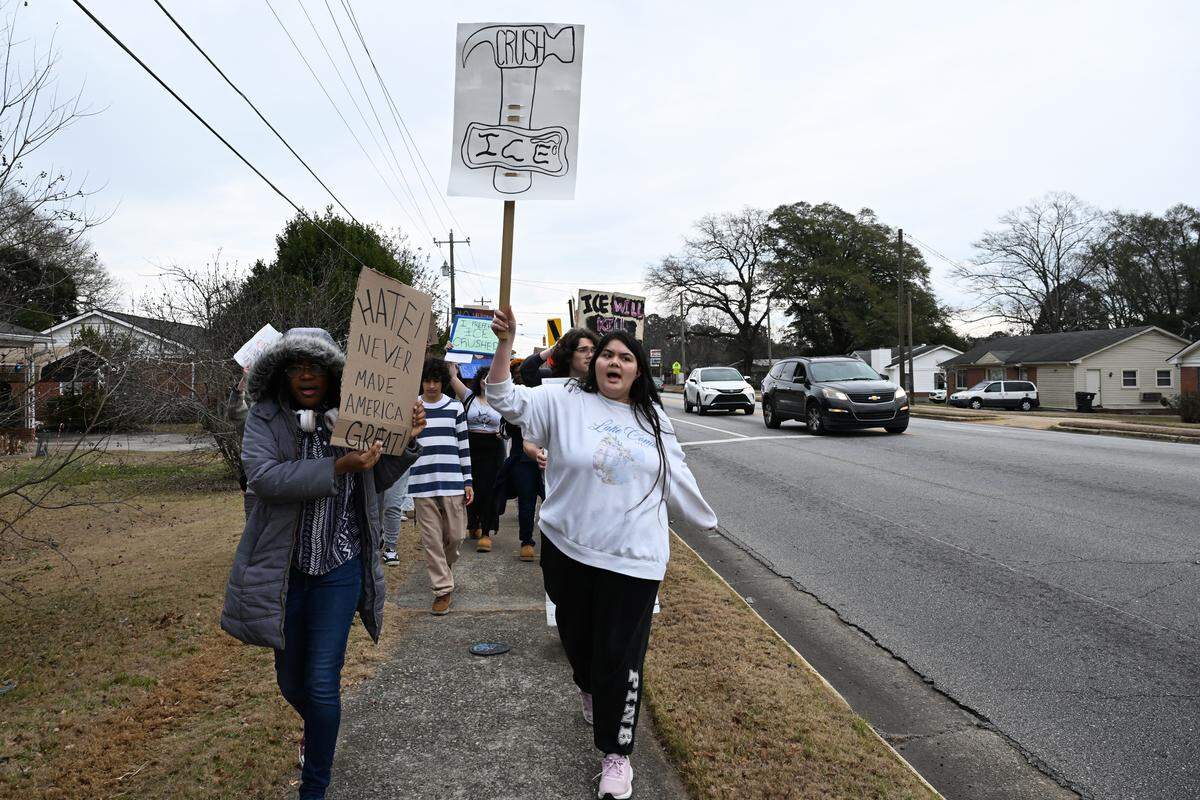 Northside High School junior Samantha Thurman, right, walks with fellow student Jackson Crabbe along Green Street to protest U.S. Immigration and Customs Enforcement (ICE) on Friday, Jan. 23, 2026, in Warner Robins, Georgia. The march occurred during school hours.