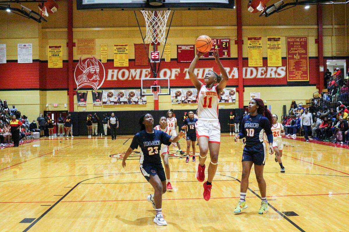 Northeast’ Jakia Little (11) shoots over two Lamar County defenders during their region playoff game player on February 18, 2022.