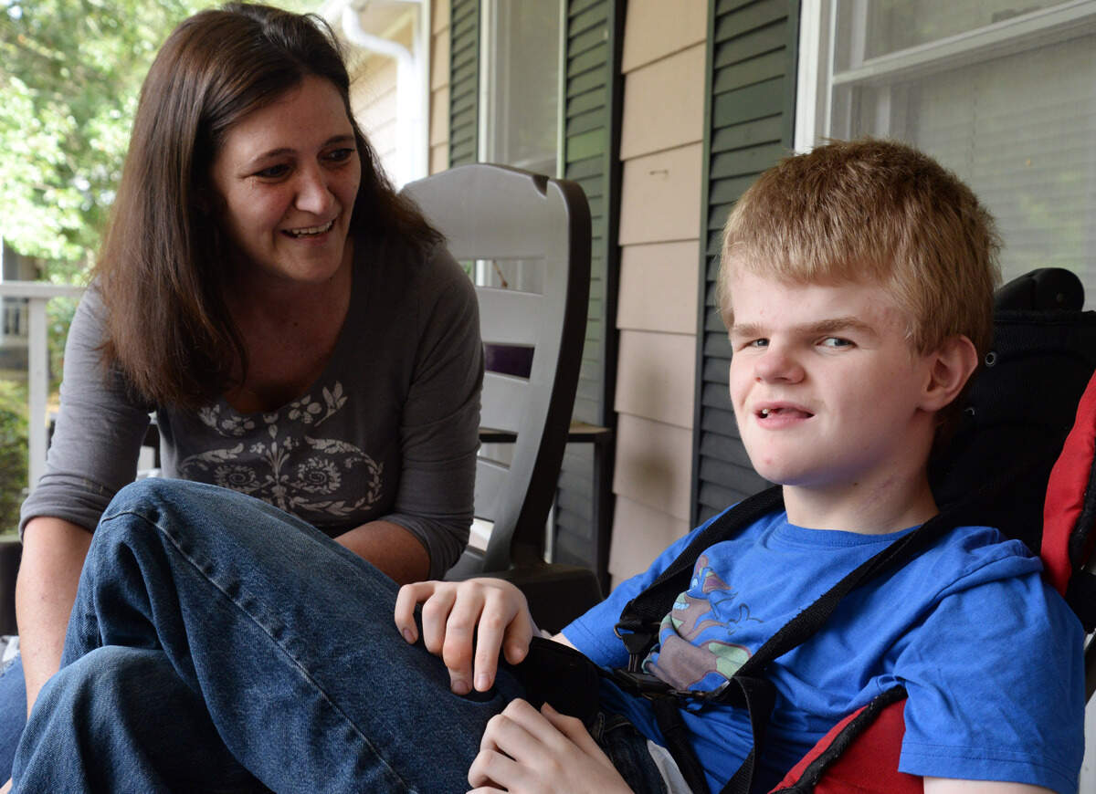 Leslie Johns, left, sits with her son, Darrell, on her sister’s front porch in September. Darrell was born with hydrocephalus and epilepsy, which are neurological conditions that have stunted his development and cause seizures. Leslie says medical marijuana has significantly benefited his health.