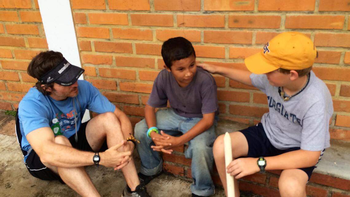 Spencer Slade, far right, shares his faith at a Honduran orphanage as his father, Lance Slade, who speaks Spanish, interprets on a medical mission trip in 2014. The boy would be adopted by the Slade family of Warner Robins and choose the name Henson Edward Slade because he wanted to have a new name as he started his new life.