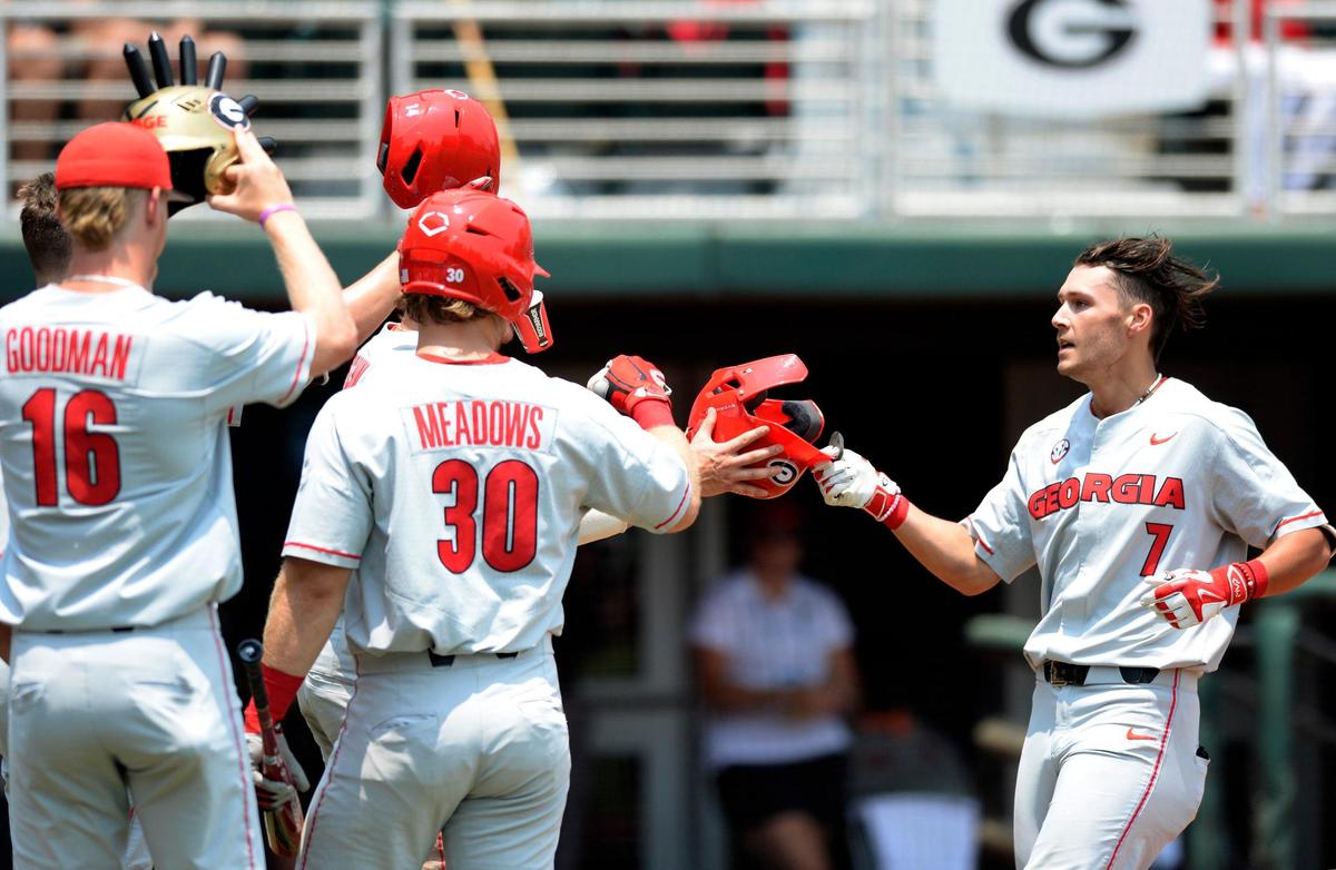 Georgia shortstop Cam Shepherd (7) gets greeted by teammates outside the dugout after his solo home run in the top of the sixth inning of the Bulldogs’ NCAA regional game against Florida Atlantic Sunday in Athens.
