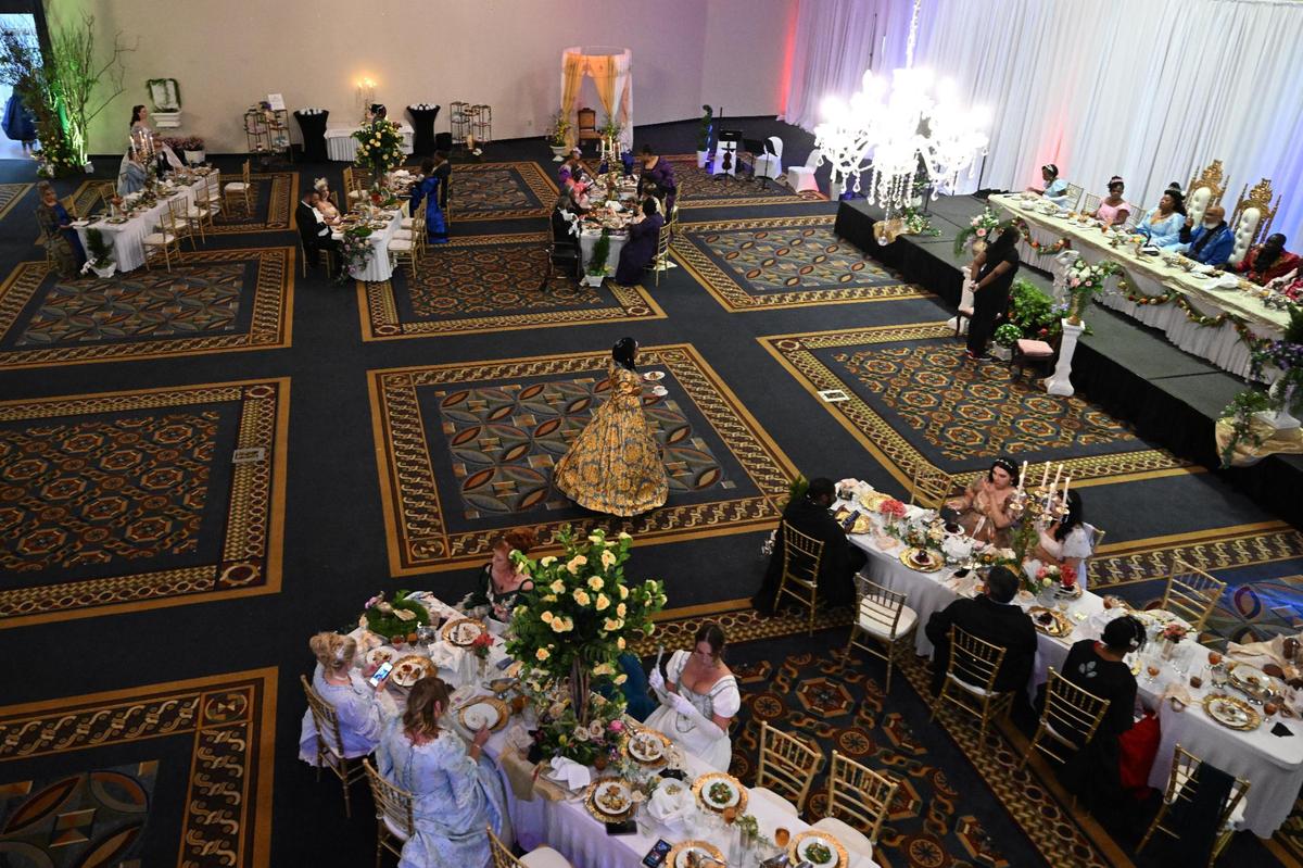 Guests dine at long tables throughout the Anderson Conference Center at Queen Elizabeth’s Royal Ball on Saturday, April 26, 2025, in Macon, Georgia. Guests dressed in regency era ballgowns and suits at the event inspired by the hit Netflix series “Bridgerton.”