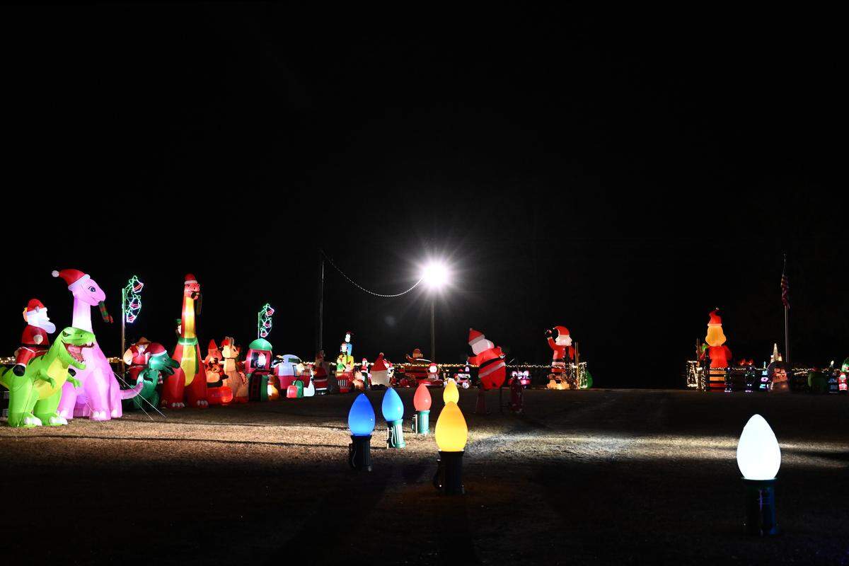 Headlines shine on a line of inflatables at the Silobrate Christmas Lights on Tuesday, Dec. 16, 2025, in Fort Valley, Ga. More than 100 festive inflatables and even more lights sit on Melissa Taylor’s property, which she opens to the public for a drive-thru display. 