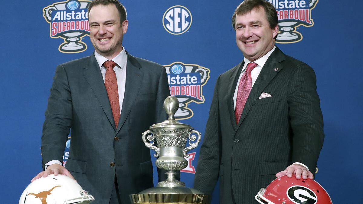 Georgia head coach Kirby Smart, right, and Texas head coach Tom Herman laugh during their photo opportunity with the Sugar Bowl trophy at a press conference on Monday, Dec 31, 2018, in New Orleans. (Curtis Compton/Atlanta Journal-Constitution via AP)