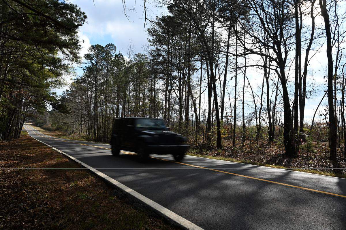 A vehicle drives down Johnstonville Road on Tuesday, Dec. 9, 2025, in Forsyth, Georgia. The Forsyth Technology Campus is proposed for land around Johnstonville Road, which would consist of up to 12 million square feet of technology facility buildings.