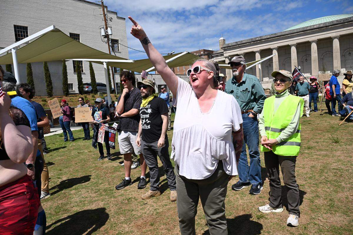 Middle Georgia Democratic Socialist of America member Heather Voiselle, from Macon, points and shouts at Bibb County Sheriff David Davis after he was invited to speak during the No Kings Protest on Saturday, March 28, 2026, in Rosa Parks Square downtown Macon, Ga. Voiselle and other Middle Georgia DSA members opposed Davis speaking at the rally, pointing to the sheriff’s office’s cooperation with U.S. Immigration and Customs Enforcement agency.