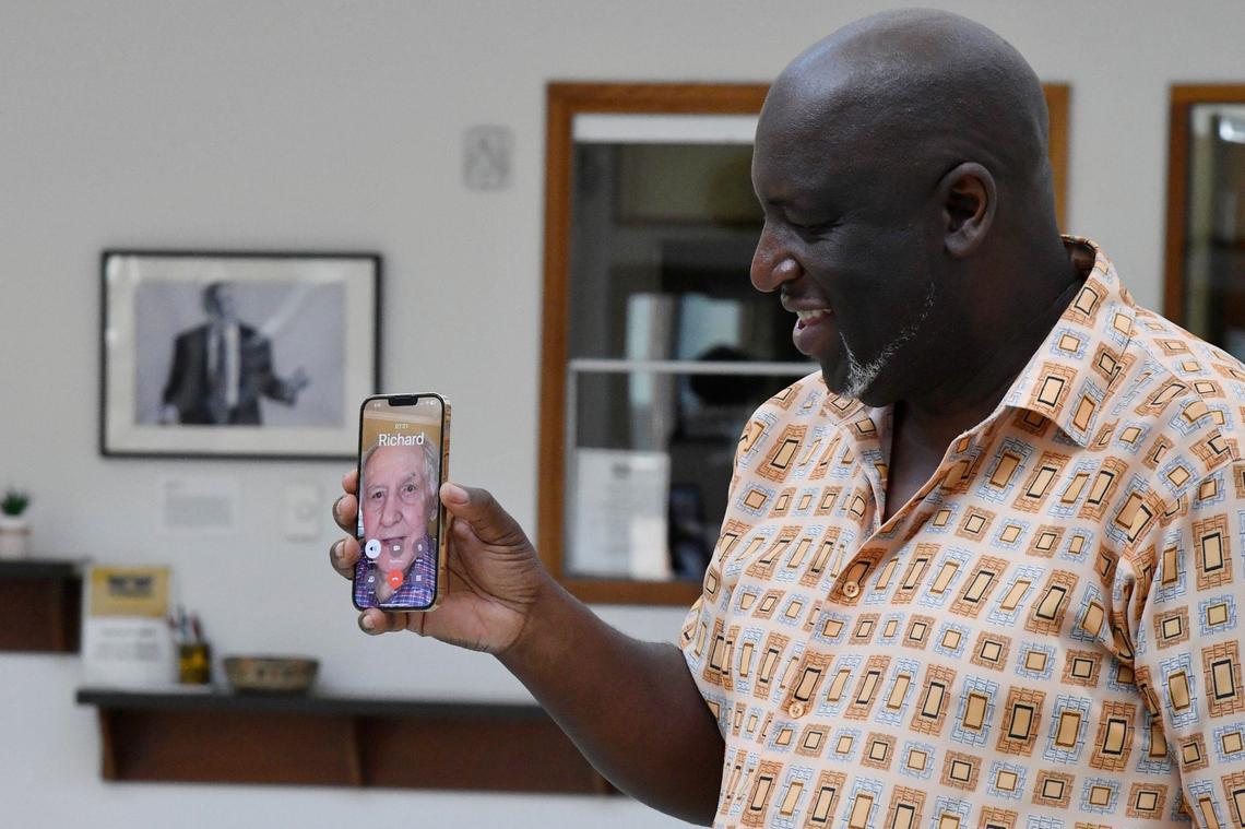Tubman Museum executive director Harold Young holds his phone while calling museum founder Richard Keil to celebrate his 91st birthday on Friday, May 24, 2024, at the Tubman Museum in Macon, Georgia. Tubman Museum staff and volunteers celebrated Keil’s birthday virtually, as he spoke to those gathered from hospice care.