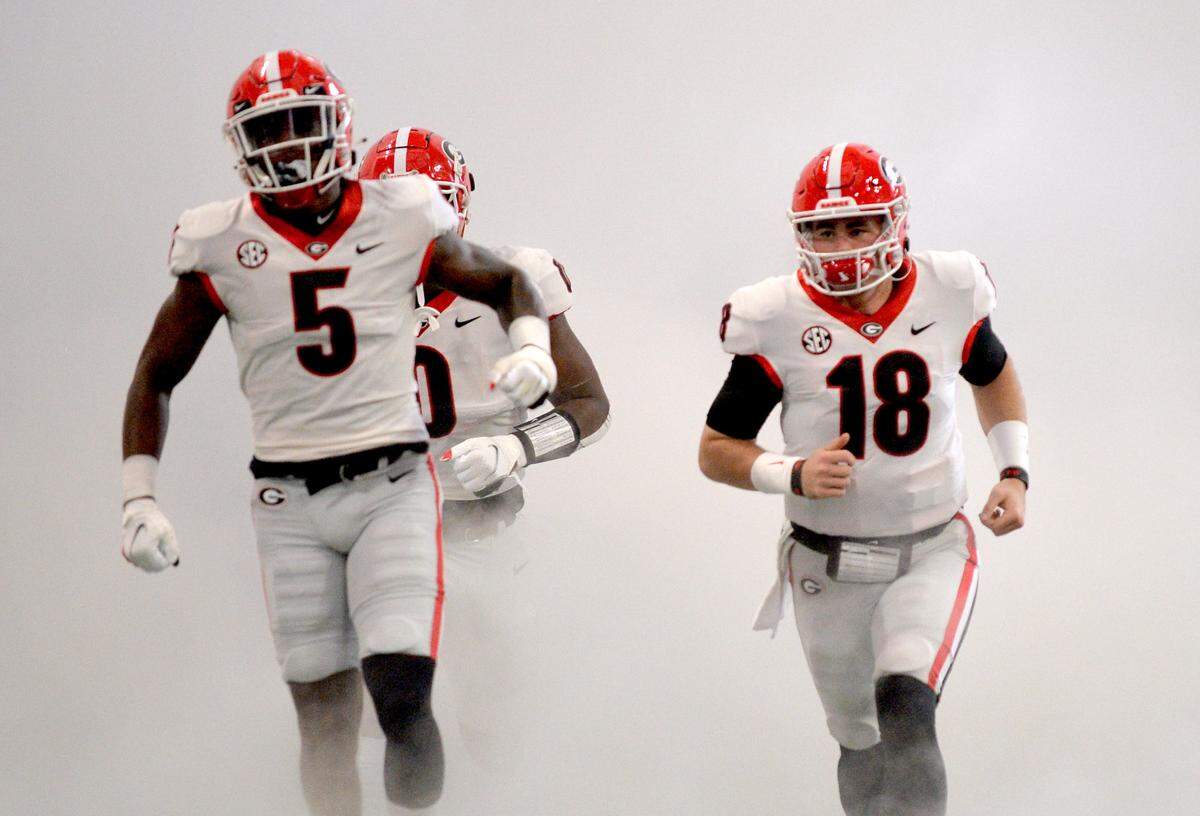 Georgia players run into Mercedes Benz Stadium in Atlanta Saturday prior to the Bulldogs’ SEC Championship game against Alabama.