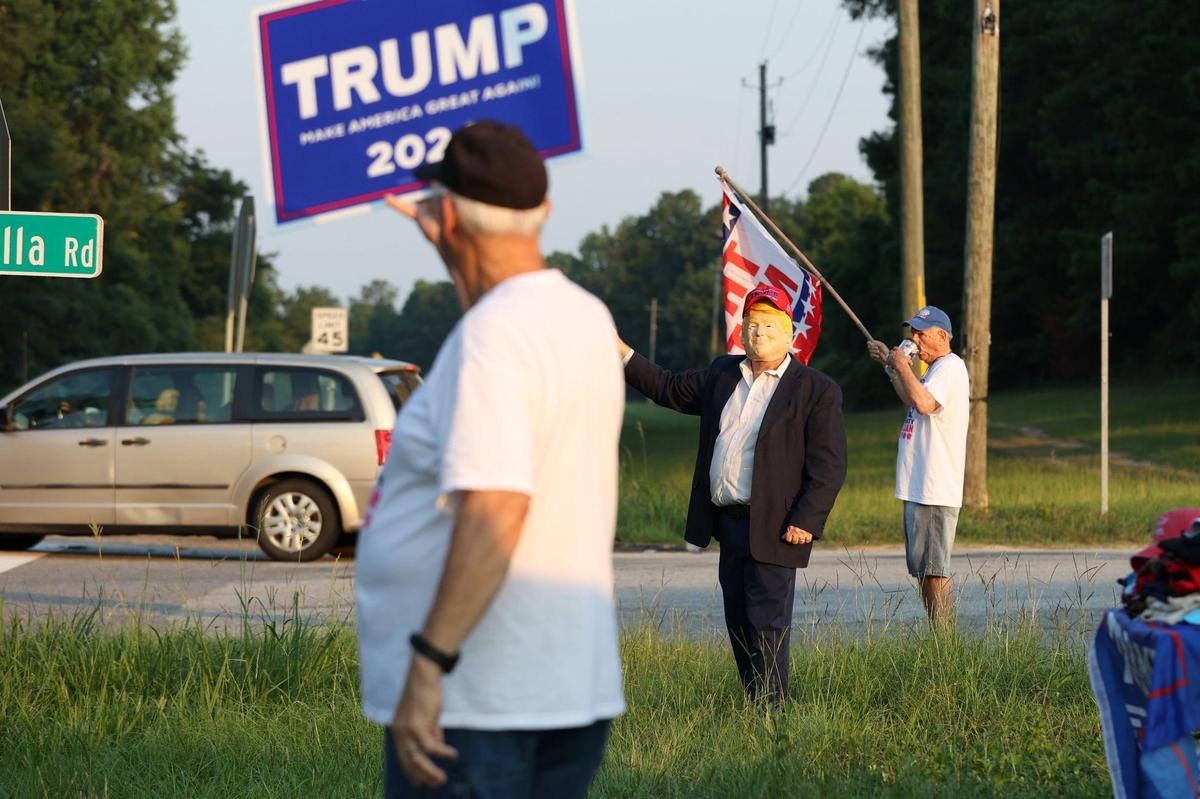 From left to right: Aubrey Clark, David Sumrall and Douglas Burnam show support for presidential candidate and former president Donald Trump on the side of Eisenhower Parkway on Monday, July 15, 2024, in Lizella, Georgia. A half dozen supporters, including members of the Bibb County Republican Party, gathered two days after an attempted assassination attempt on Trump in Pennsylvania with plans to move throughout the area over the course of the day.