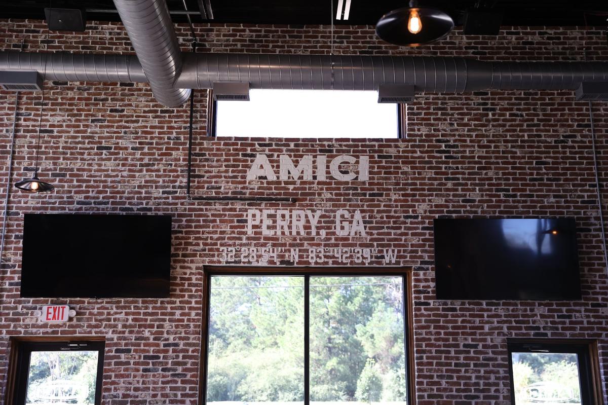 A mural above the window displays the coordinates of the new Perry location of Amici on Wednesday, Oct. 16, 2024, in Perry, Georgia. The mural was created by a Houston County High School senior with graphic artist Aaron Munn.
