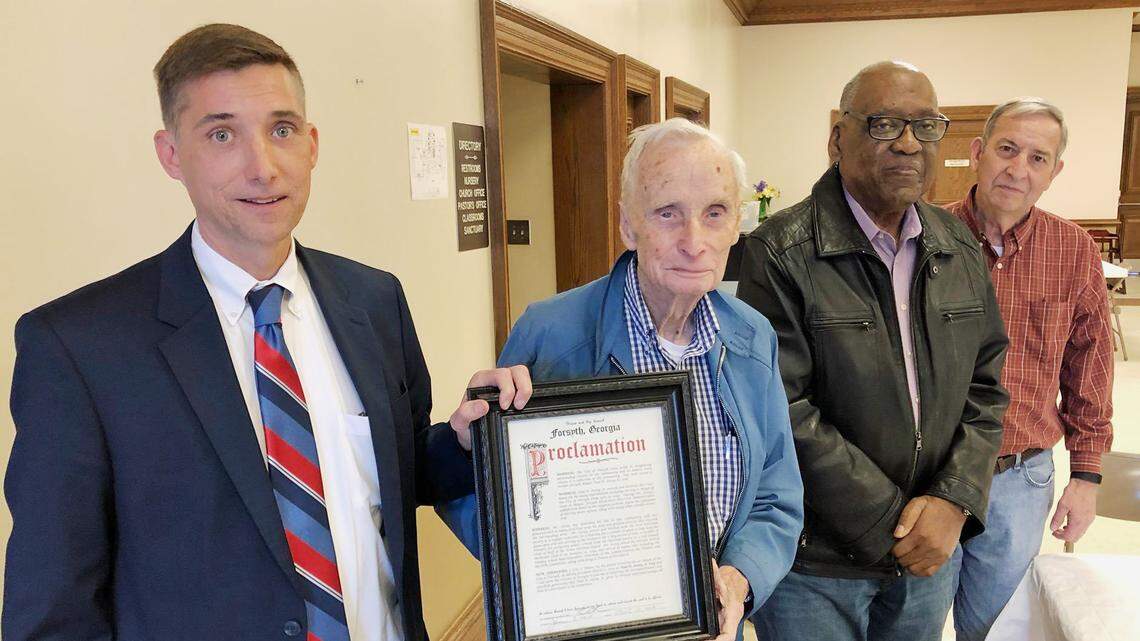 From left, Forsyth Mayor Eric Willson presents former mayor Paul Jossey with a proclamation as former mayor Ralph Ogletree and Councilman Mike Dodd look on. Jossey died Sunday.