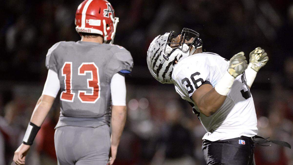 Houston County linebacker Bennie Steadman, right, celebrates after knocking Allatoona running back Charles Anderson backward during their GHSA playoff game Friday night.